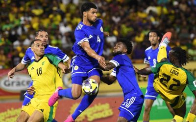 Curaçao national football players celebrating 2026 World Cup qualification after draw against Jamaica in Kingston.